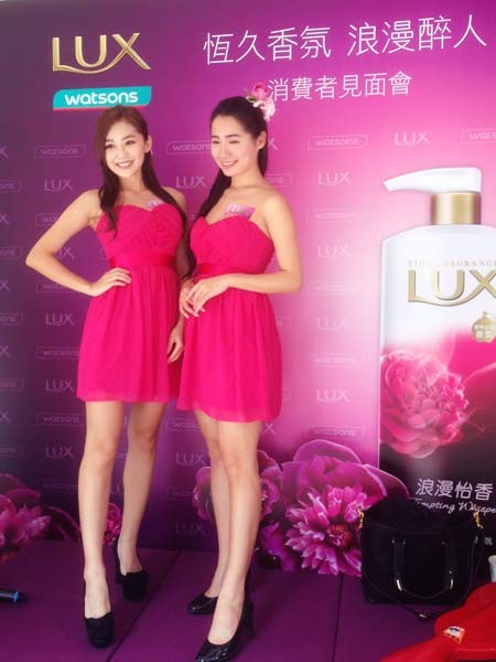 屈成氏LUX消費者見面會-接待小姐於活動背板前合照